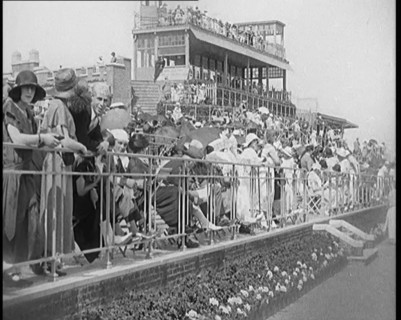 A Large Crowd of Civilians Wearing Smart Outfits and Hats Watching a Horse Race, 1920. Creator: British Pathe Ltd.