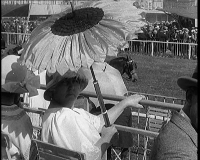 A Female Civilian Emerging from Behind a Sun Flower Shaped Parasol, 1920. Creator: British Pathe Ltd.