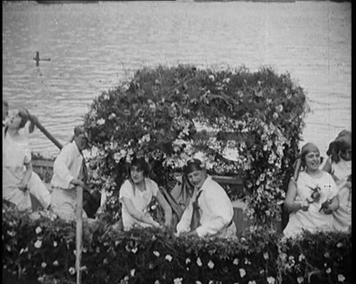 Civilians on a Boat Heavily Decorated with Flowers, 1920. Creator: British Pathe Ltd.