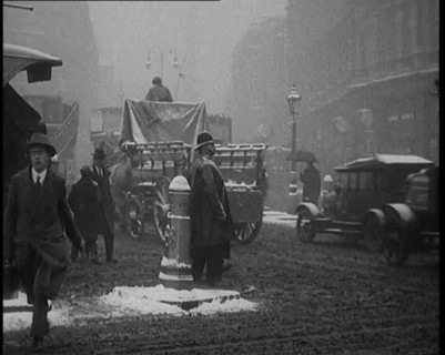 British Civilians Going About their Daily Commute on a Snowy Day on the Streets Watched by..., 1920. Creator: British Pathe Ltd.