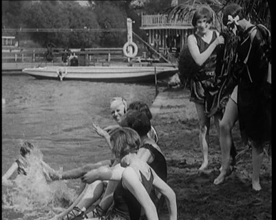 A Group of Young Female Civilians Wearing Swimsuits Playing on Riverside, 1920. Creator: British Pathe Ltd.