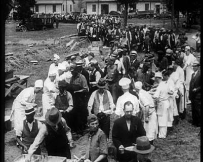 American Civilians Serving Meals for a Large Crowd on a Queue Outdoors, 1930. Creator: British Pathe Ltd.