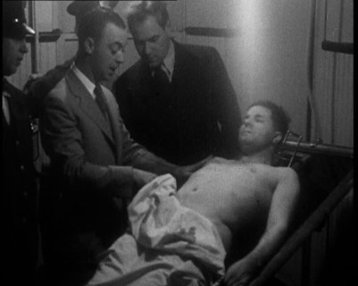 Male American Civilians Examining a Dead Body, 1930. Creator: British Pathe Ltd.
