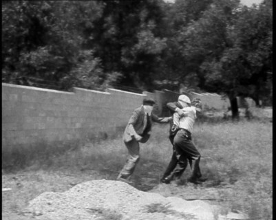 Two Male American Civilians Covering Their Faces with Handkerchiefs Carrying a Male American...1930. Creator: British Pathe Ltd.