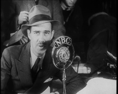 A Male American Civilian in a Press Room Speaking at a Microphone That Has the Words NBC..., 1930s. Creator: British Pathe Ltd.