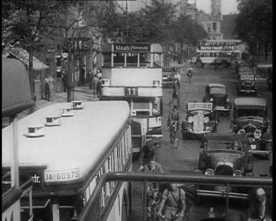 Buses, Cars and People on Bikes Driving Down the Road, 1933. Creator: British Pathe Ltd.