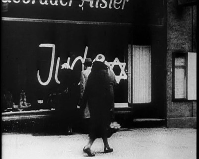 Civilians Looking at  Shop Window with Graffiti Reading: ‘Juden’ on it, 1933. Creator: British Pathe Ltd.