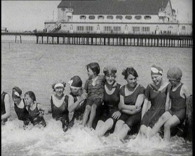 Women and Children Sitting on a Groyne, Splashing With Their Feet on a British Beach, 1920. Creator: British Pathe Ltd.