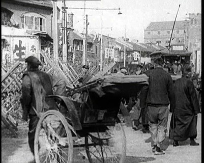 A Male Chinese Civilian Pulling Rickshaws Through the Streets of Shanghai Past Barricades, 1920s. Creator: British Pathe Ltd.