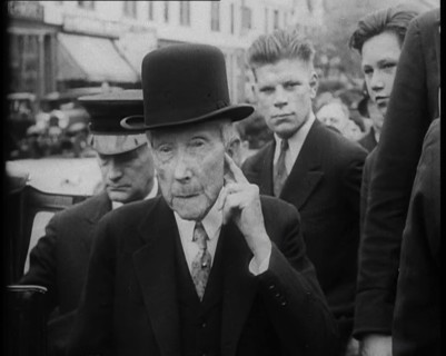 John D. Rockefeller Standing with Other People Next to a Car, 1933. Creator: British Pathe Ltd.