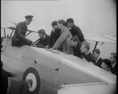 An RAF Officer Showing a Group of Male Children His Aeroplane, 1931. Creator: British Pathe Ltd.
