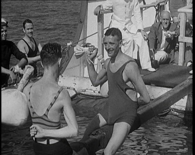 Two Male Civilians in Swim Suits Sitting on a Pole and Enjoying a Pillow Fight in Front..., 1931. Creator: British Pathe Ltd.