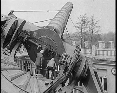 Large Telescope Being Turned by Two Civilians, 1931. Creator: British Pathe Ltd.