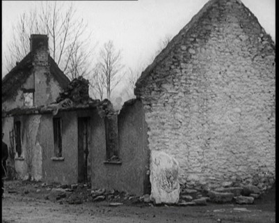A Man Standing Outside a Burnt Out Cottage in Ireland, Holding a Bicycle, 1921. Creator: British Pathe Ltd.