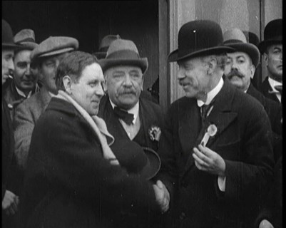 British Man Exiting a Building and Shaking Hands as Part of a by Election Campaign, 1921. Creator: British Pathe Ltd.