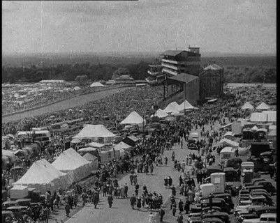 Large Crowd Sitting Outside with Cars and Tents, 1933. Creator: British Pathe Ltd.