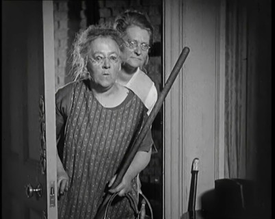 Scene from the Film 'The Compulsory Husband': Two Actors Portraying Cleaners Carrying..., 1920s. Creator: British Pathe Ltd.