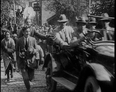 Crowd Chasing a Motorcar as It Climbs up a Hilly Cobbled Street, 1920. Creator: British Pathe Ltd.