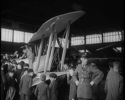 An RAF Officer Showing a Group of Male Children His Aeroplane, 1931. Creator: British Pathe Ltd.