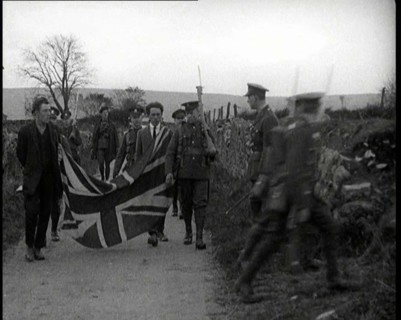 British Soldiers Marching a Sinn Fein Supporter Down a Country Lane, Forcing Him to Bear..., 1920. Creator: British Pathe Ltd.
