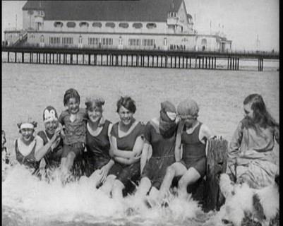 Women and Children Sitting on a Groyne, Splashing With Their Feet on a British Beach, 1920. Creator: British Pathe Ltd.