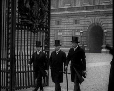Three Male British Members of Parliament Walking Away from Buckingham Palace, Passing..., 1924. Creator: British Pathe Ltd.