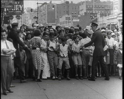 Crowded New York City Street Where Police and Ambulance Attend to Dead and Dying Victims..., 1932. Creator: British Pathe Ltd.
