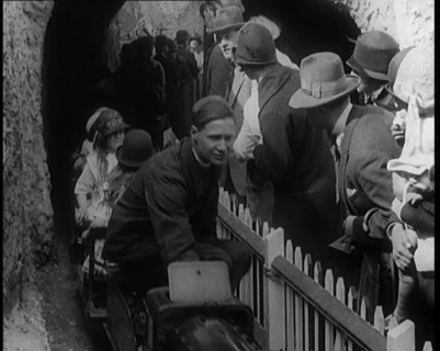 A Model Train Passes Through a Tunnel As a Crowd of People Watch from Behind a Fence, 1924. Creator: British Pathe Ltd.