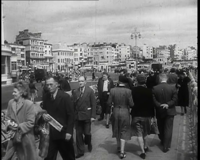 A Cloudy Day as Male and Female Pedestrians are Walking on the Promenade at  Brighton..., 1939. Creator: British Pathe Ltd.