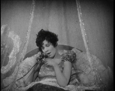 Scene from a 1920s Film. A Female Actor Speaking on the Telephone in Bed Still Wearing Her..., 1920s Creator: British Pathe Ltd.