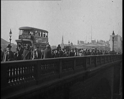Pedestrians And Commuters Crossing London Bridge With Buses in the Background, 1920s. Creator: British Pathe Ltd.