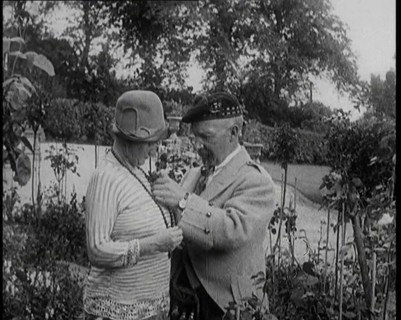 Sir Harry Lauder Giving Flowers to His Wife, Lady Ann Lauder, at Home in Scotland, 1920s. Creator: British Pathe Ltd.