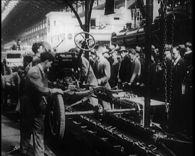 A Group of Male Civilians Building a Car As a Crowd of People Watch. Behind the Crowd..., 1924. Creator: British Pathe Ltd.