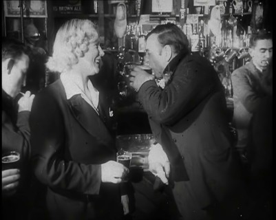A British Woman and a British Man Standing at  the Bar Holding Drinks in a Public House..., 1939. Creator: British Pathe Ltd.
