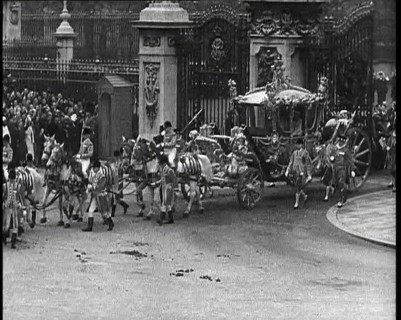 The Royal Coach, Horses, and Procession Filing Out of the Gates at the Front of Buckingham..., 1937. Creator: British Pathe Ltd.