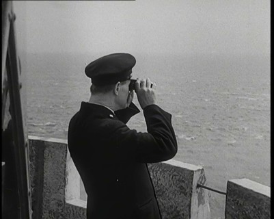 Lighthouse Keeper Looking Through Binoculars at the Turbulent Sea, 1920s. Creator: British Pathe Ltd.