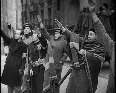 Armed Men and Civilians Making Fascist Salutes in a Street in Madrid, All Dressed in Thick..., 1939. Creator: British Pathe Ltd.