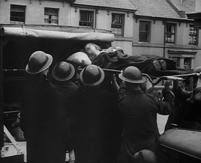 An Injured Child Being Carried Into an Ambulance, 1940. Creator: British Pathe Ltd.