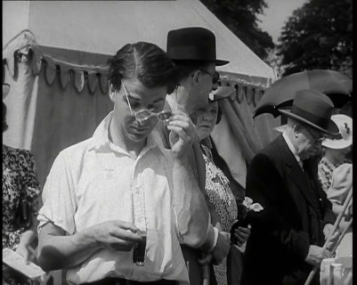 Emlyn Williams, Actor, Timing Punters by the 'Fishing for Fizz' Stall at  the Theatrical..., 1939. Creator: British Pathe Ltd.