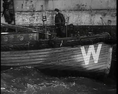 Small Wooden Customs Boat With Male Crew Member Standing at  the Bow End Alongside..., 1939. Creator: British Pathe Ltd.
