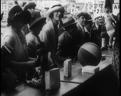 A Crowd of People Playing a Game Where They Have to Pop a Balloon By Turning a Handle, 1924. Creator: British Pathe Ltd.