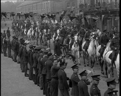 Military Parade of Mounted British Soldiers Riding Down a Street Decorated With Bunting, 1937. Creator: British Pathe Ltd.