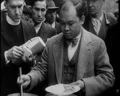 Man Serving Meals For Group of People from the Street Kitchen, 1932. Creator: British Pathe Ltd.