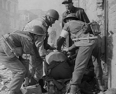 British Medics Helping a Fellow Soldier, 1943-1944. Creator: British Pathe Ltd.