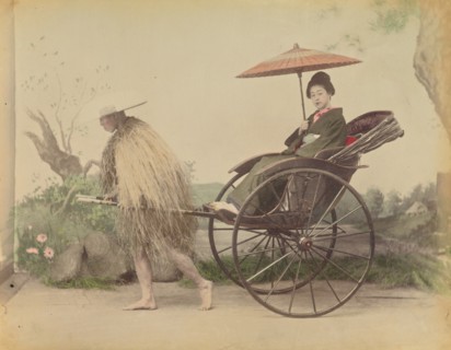 Woman with Parasol Posed Being Pulled in a Jinrikisha by a Man Wearing a Straw Rain Coat,1870s-1890s Creator: Kusakabe Kimbei.