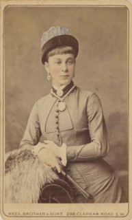 Unidentified woman standing, holding a fan, 1879. Creator: David Rees & Brother & Son.