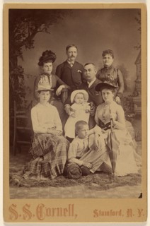 Group family portrait of eight members, 1889. Creator: SS Cornell.