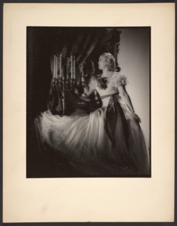 Woman lighting candelabra, 1930s. Creator: Gunther Krampf.