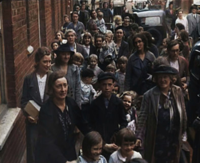 British Women and Child Evacuees Walking Along the Pavement of a Residential Street Next..., 1939. Creator: British Pathe Ltd.