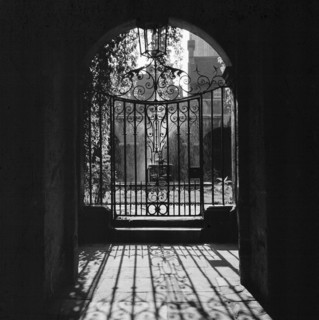 View looking through a decorative wrought iron gate in the Little Cloister at Westminster Abbey,